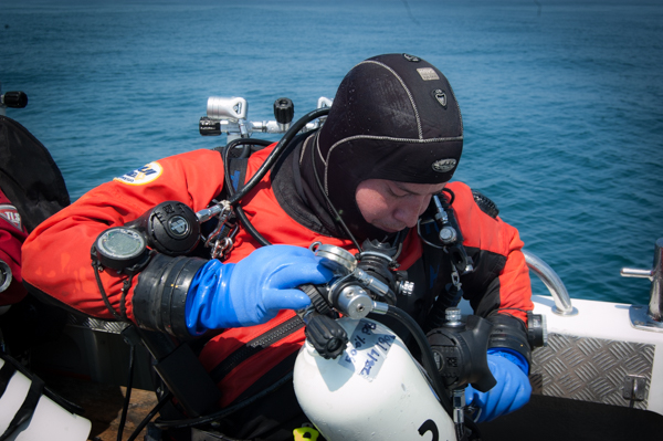 diver loads a decompression stage cylinder before a dive